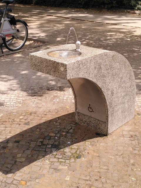 A continuously running and overflowing drinking water fountain at Lausitzer Platz, Berlin-Kreuzberg.
