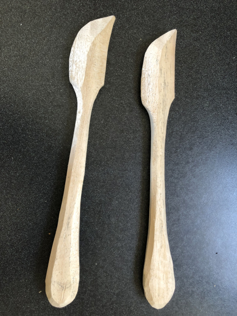 Dos palitas para untar mantequilla, a medio hacer. 