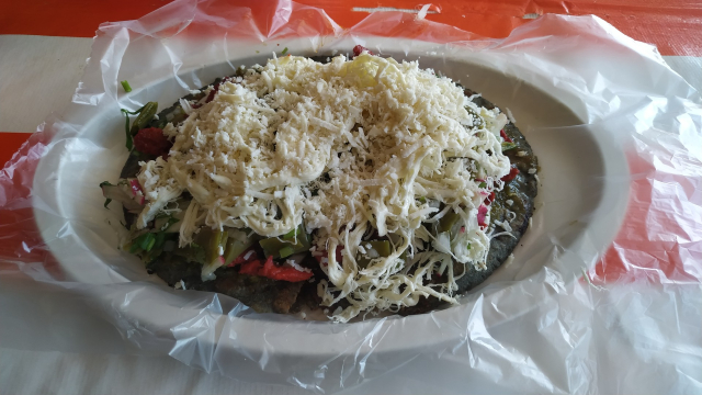 Un delicioso huarache servido en un plato oval como sí mismo.

El huarache es una comida mexicana consistente en una base oval de masa atascada con ingredientes arriba hasta reventar.

Este tiene alberjón adentro, carne enchilada, nopales, queso de hebra y queso fresco 