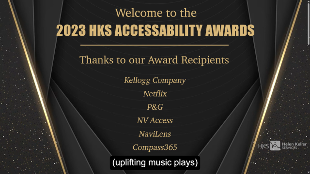 Screenshot of the start of the video.  A decorative dark brown and gold background with text:
"
Welcome to the
2023 HKS ACCESSABILITY AWARDS
---
Thanks to our Award Recipients
Kellogg Company
Netflix
P&G
NV Access
NaviLens
Compass365
"
At the bottom is the first line of captions which reads "(uplifting music plays)".  Now you'll need to watch the awards to hear what the uplifting music is!