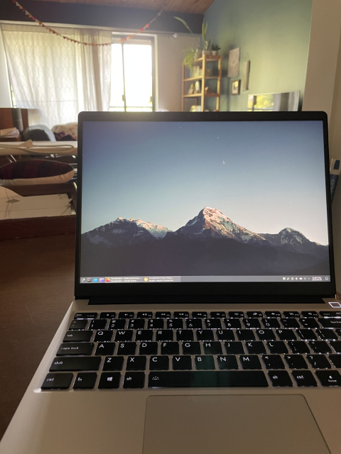 My laptop on a table, in the background you can see various bits of my living room