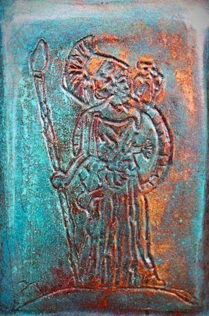 A close up of the Athena etching on the middle of the front of a raku pottery vase.