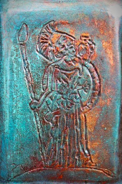 A close up of the Athena etching on the middle of the front of a raku pottery vase.