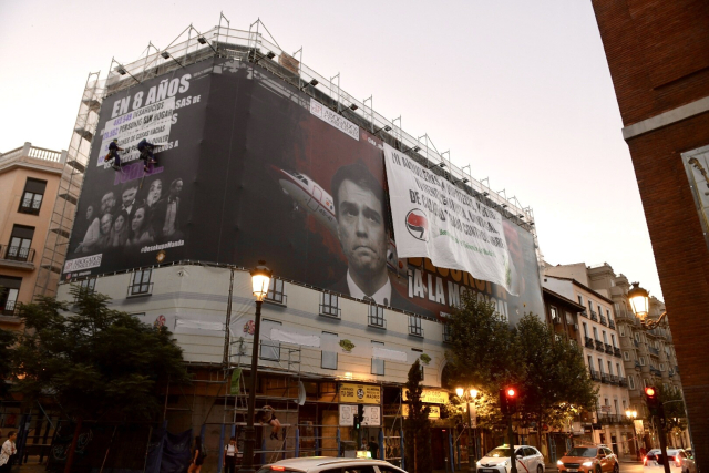 La lona de desokupa tapada con dos pancartas del movimiento de vivienda de Madrid
