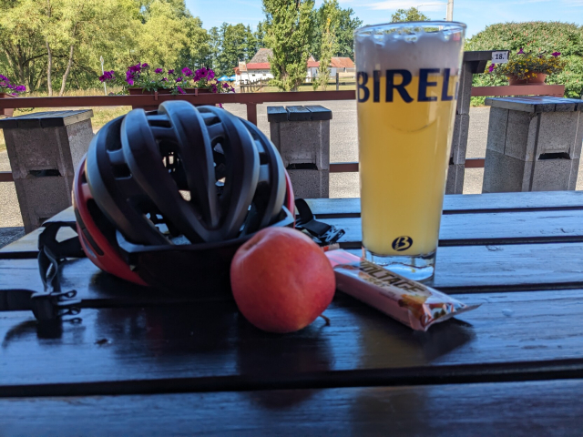 Na obrázku je cyklistická helma u půllitru Birella 
