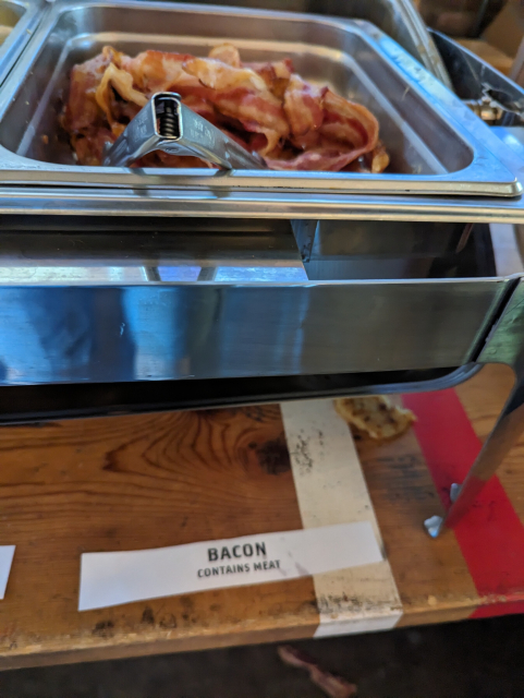 A tray of bacon with a label that says:

BACON
CONTAINS MEAT