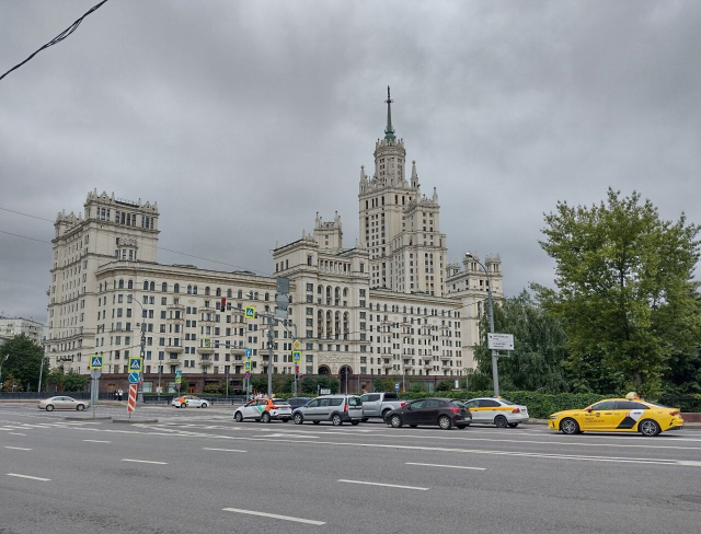 Вид через дорогу на величественную высотку на Котельнической набережной, небо серое, облачное.