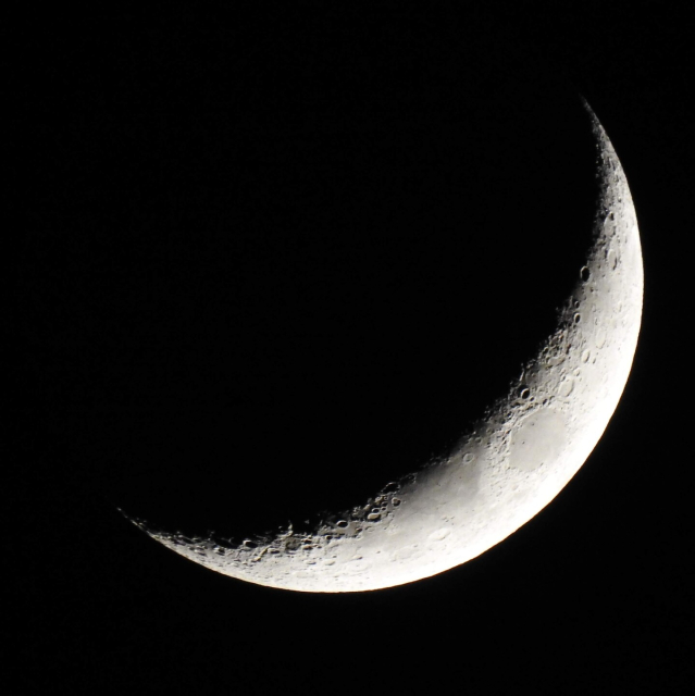 Černobílá detailní fotografie Měsíce, který je zhruba v první čtvrti dorůstání (je to zkrátka takový ten srpek jak z turecké pohádky).