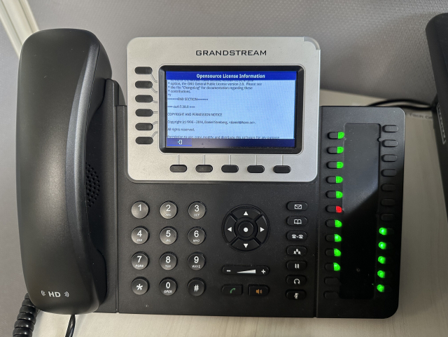 A corded telephone with a small screen showing part of the curl license on it.