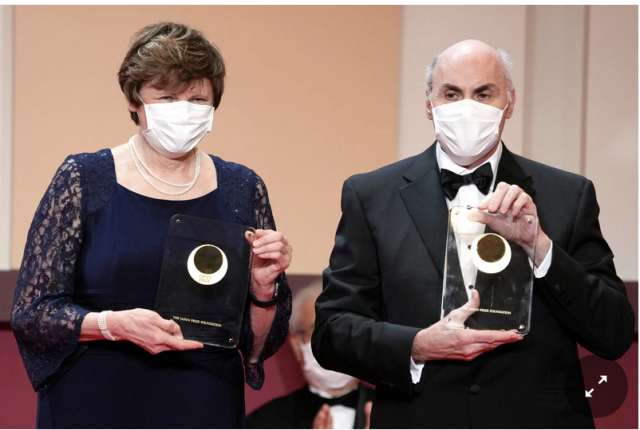 Photo of scientists Katalin Karikó and Drew Weissman accepting their Nobel prizes in evening formal wear and masks.