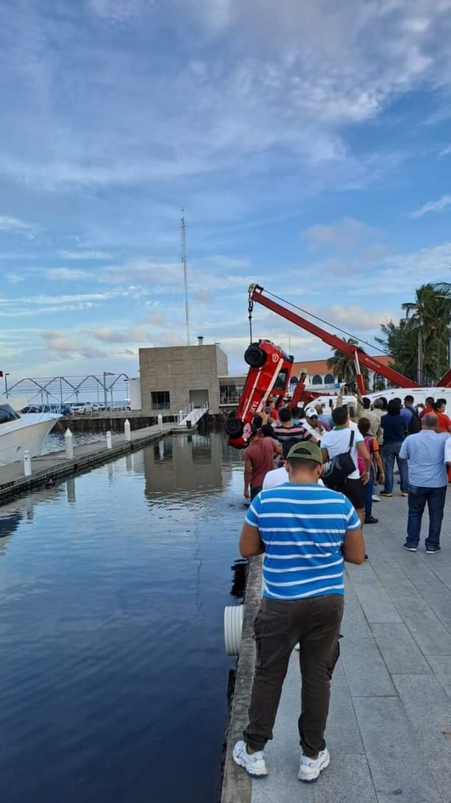 Fotografía de una grúa extrayendo un taxi de las profundidades de una bahía de yates ee Veracruz, donde fue a dar por imprudencia de su conductor.