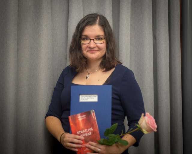 This is me looking into the camera, holding the book, a diploma and a pink rose.