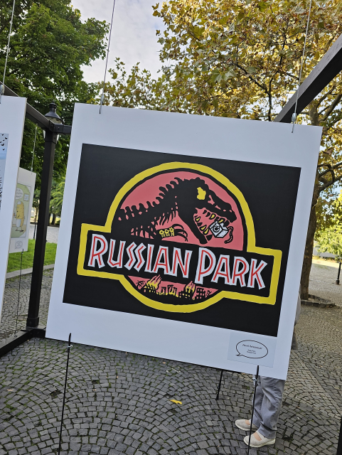 karikatúra Jurassic Park na Russian Park, dinosaurs má v tlame práčku 