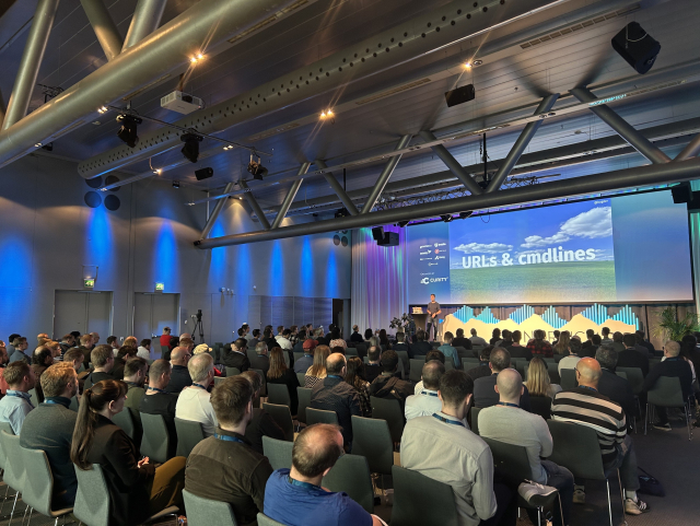 Daniel far off, talking  "next level curl" in front  of an big audience