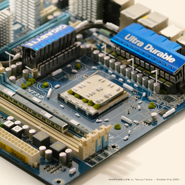 Photo by miniature artist Tatsuya Tanaka, turning a motherboard into a bus and train station with the addition of assorted tiny vehicles and clever framing.