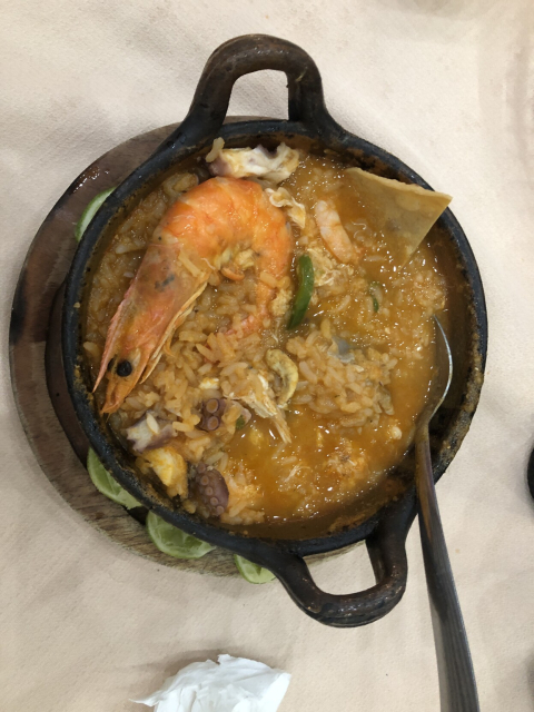 Cazuelita de barro llena de arroz a la tumbada: arroz rojo caldoso, repleto de mariscos y chile jalapeño.