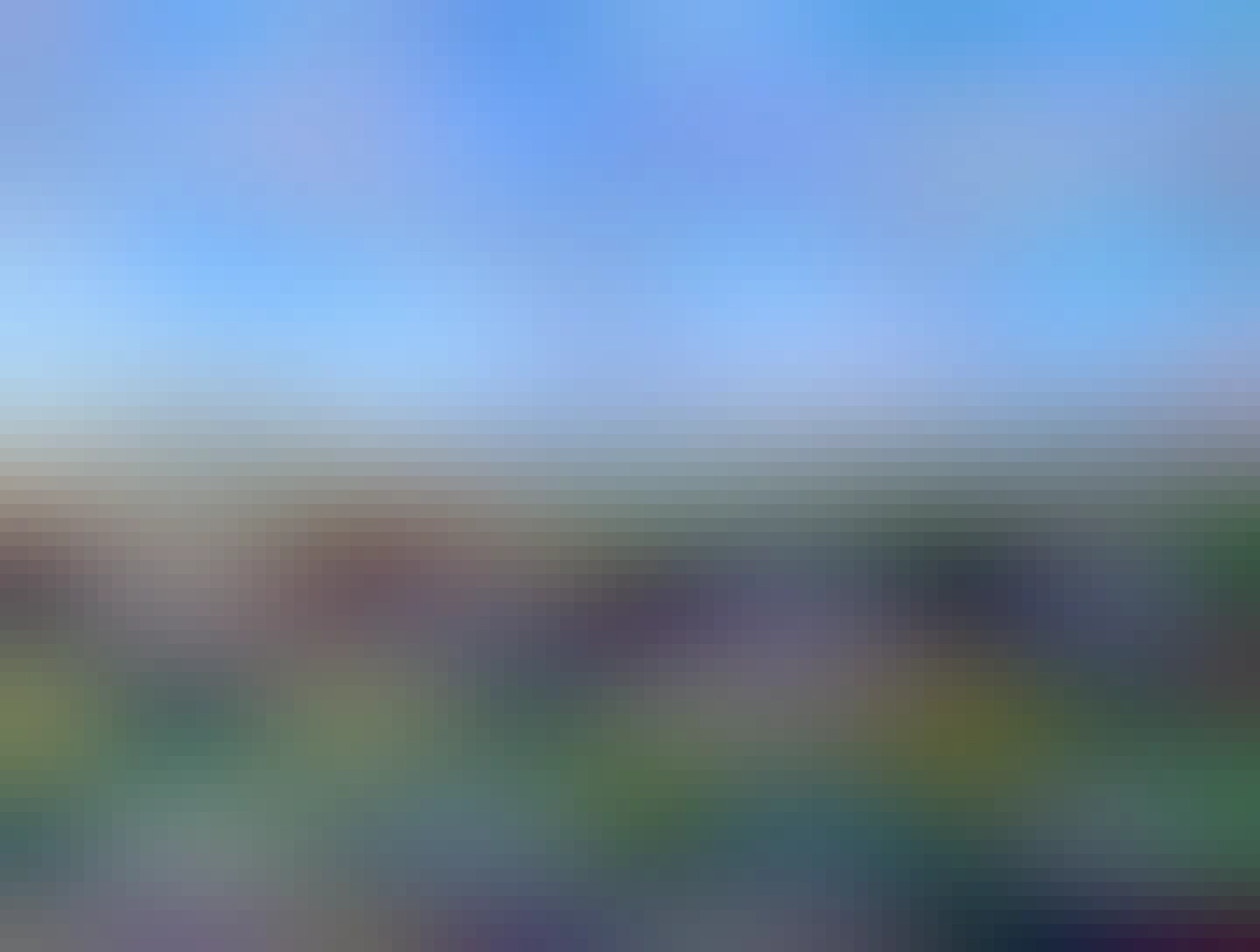 širokouhlý záber od hradu v Bratislave, je vidieť most SNP a tú podrozelenú vežu, mnoho oražovohnedých striech, je vidieť aj Dunaj a najezd a zjezd ze silnice, modrá obloha s pár mrakmy, 