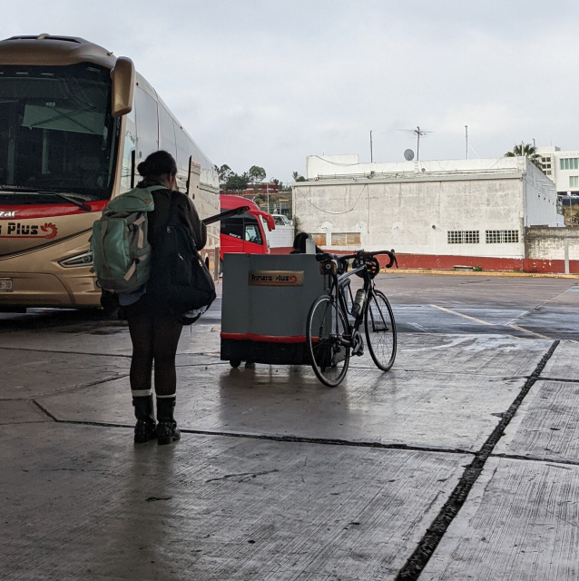 a bicycle rests next to a bus counter, unattended. Where will it go next? what new adventures will it find?