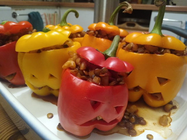 Roasted peppers carved like Halloween pumpkins on a tray