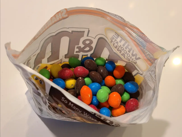 An open bag of m&m's, where the top of the bag is all air.