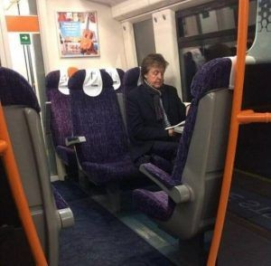 Picture shows Sir Paul McCartney sitting on a train reading a book.