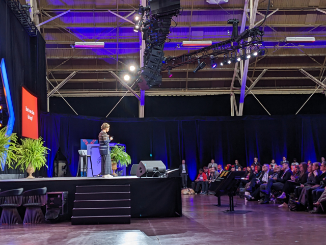 Jennifer Pahlka on stage at FWD50. Her slides on the far side say "How do we close the loop?" 