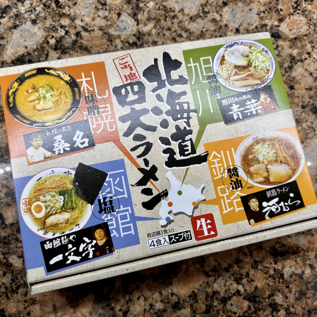 A gift box of four types of ramen with photos of chefs and a description of what they are. Two of them are soy sauce based (shoyu), one is a clear salty broth (shio) and another is miso. Each is a specialty from a place marked on a map on the box including Sapporo and Hakodate