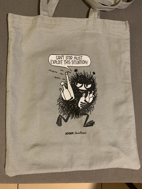 Stinky the Moomin on a canvas bag running off holding a bunch of bottles with a speech bubble: “Can’t stop. Must exploit this situation!”