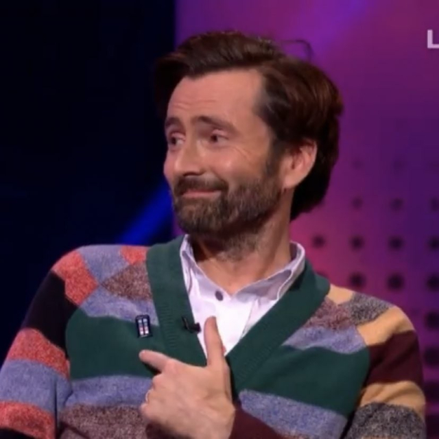 David Tennant looking as good as ever in a stripey cardigan he's going to give me for Christmas but just doesn't know it yet and a tiny but potent tardis pin in trans colors 
