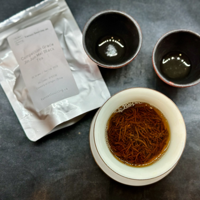 A photo of a gaiwan with black tea in it. And two small cups