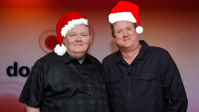 Shaun and Steven stand and smile proudly in front of the Double Tap logo dressed in what appears to be photoshopped Santa hats on their heads!