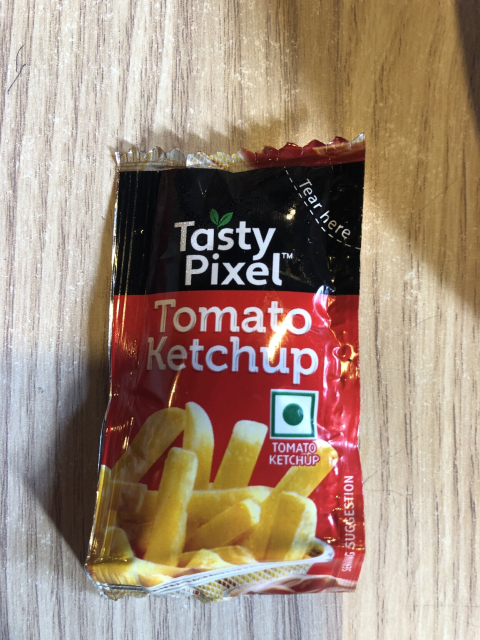 A sauce packet that says, "Tasty Pixel Tomato Ketchup"