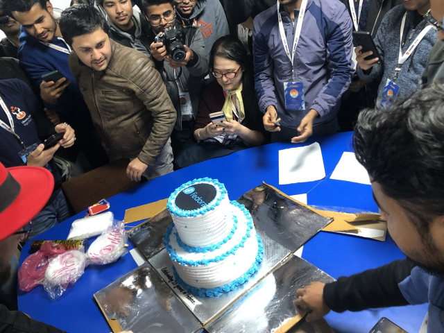 The cake is revealed! It has the Fedora logo on top.