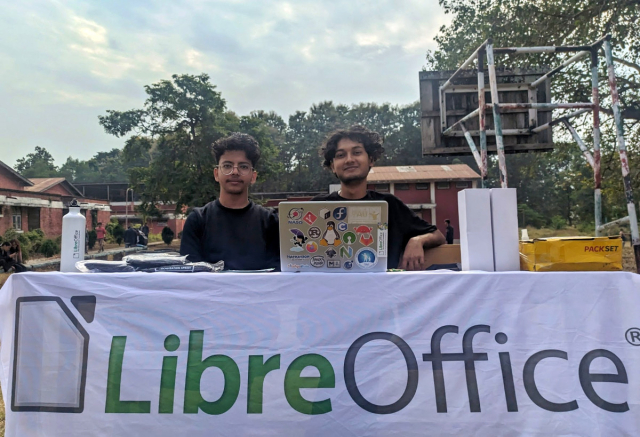 Photo of Suraj, sitting behind a LibreOffice banner