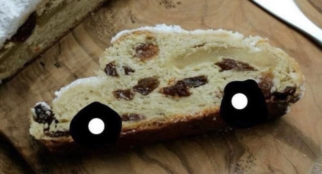 A slice of stollen that looks like the shape of a car. Someone has drawn wheels on it.