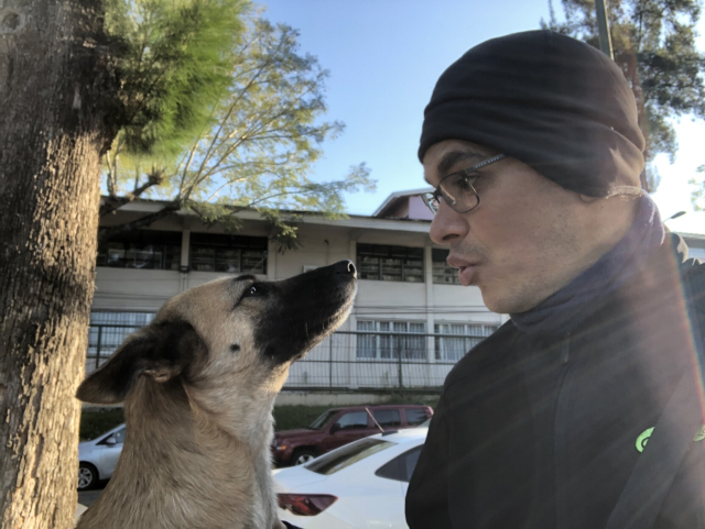 Gaia, nuestra perrita recién adoptada, y yo, viéndonos el uno al otro. Traigo gorrito porque hace frío.
