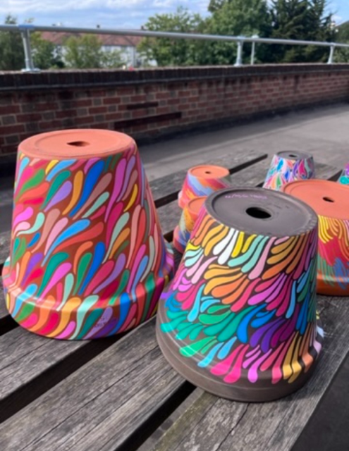Collection of hand painted, colourful patterns on terracotta pots 