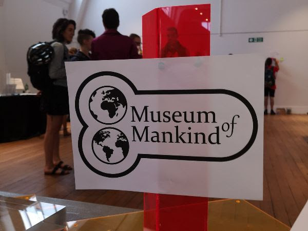 A logo of the Museum of Mankind: two globes stacked vertically, and the name of the museum, surrounded by a border which makes it look unfortunately like a cock and balls