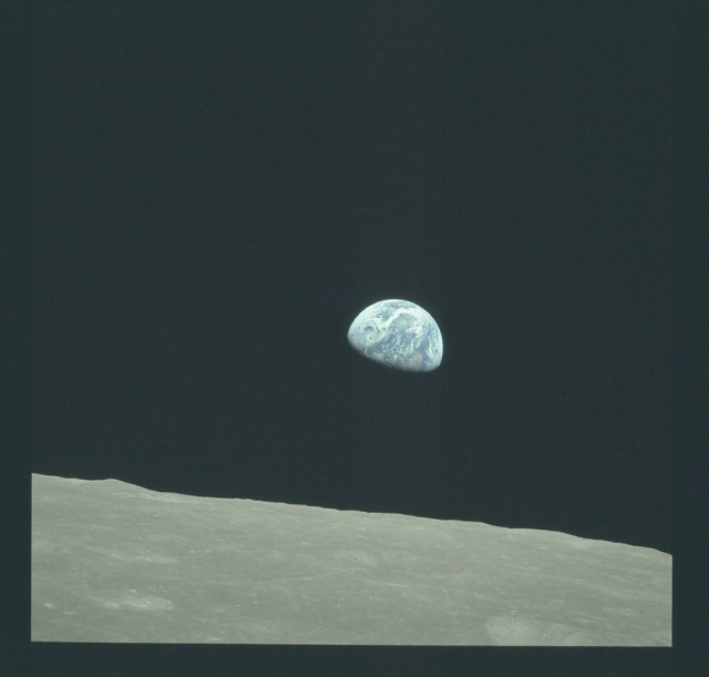 A color photo taken by the Apollo 8 astronauts of Earth rising over the horizon of the Moon.
There are subtle variations in the moons gray surface corresponding to craters and other features. The swirl of clouds is distinct on the rising Earth, along with blue oceans and tan and green land masses.