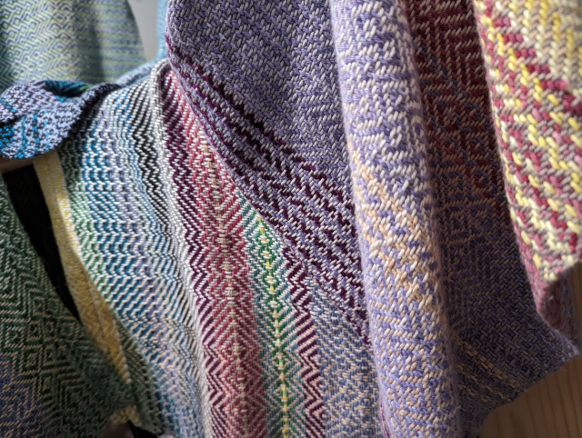 colorful twill blankets drying on a rack