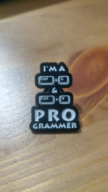Photo showing a pin with " I'm a CTRL+C & CTRL+V programmer " written in white on black