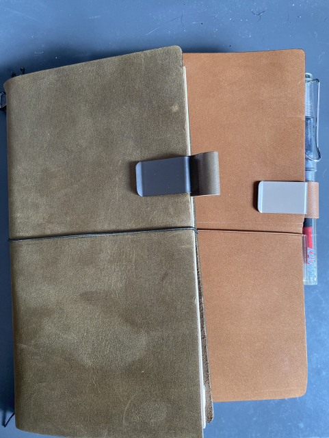 Dos cuadernos Traveller’s Notebook (uno verde y otro marrón) sobre una mesa