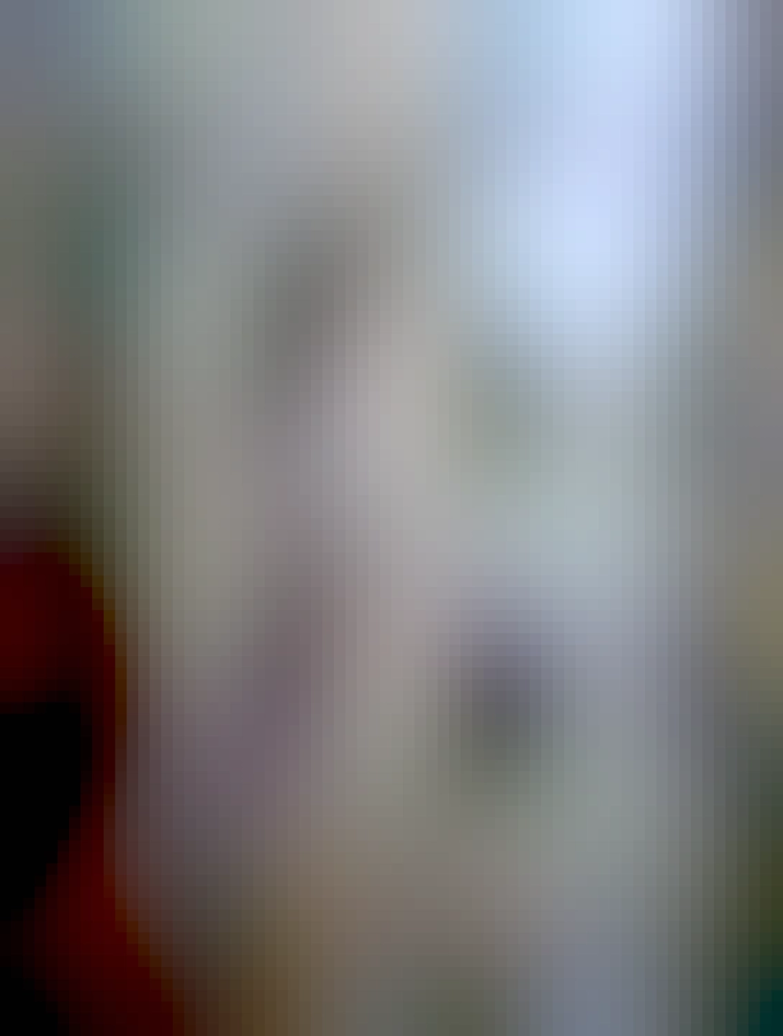 záber na domy od spodu, v záběru sú okná, stará lampa a obloha