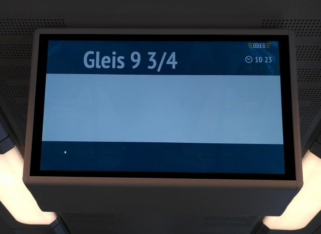 Informationsmonitor in einem Zug. In großen Buchstaben steht "Gleis 9 3/4", sonst (außer der Uhrzeit) eigentlich nichts. 