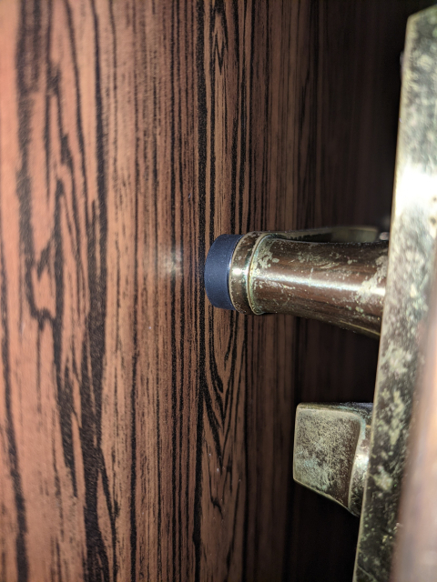 Door locked open by a magnet on wardrobe holding to a metal plate on door handle.