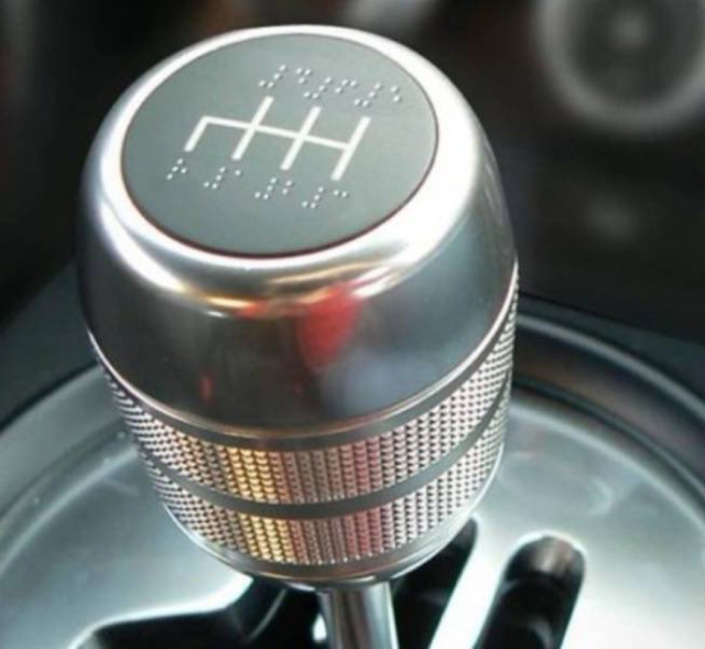 A gearshift knob labeled in braille. 