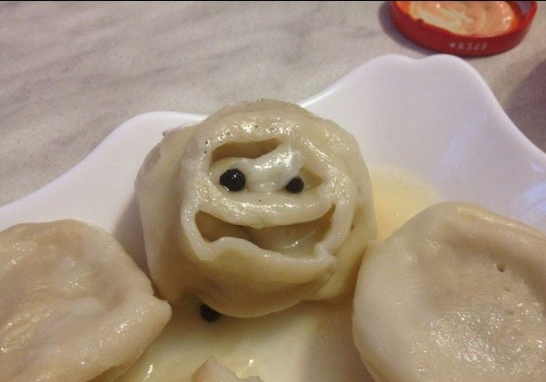 A scary looking dumpling with a grimacing face 