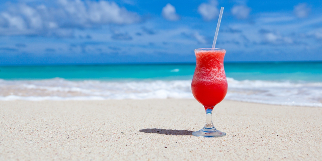 A red drink on a sandy beach