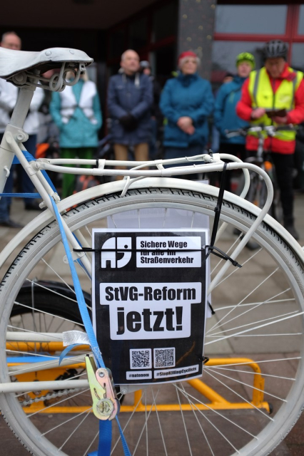 Weisses Ghostbike mit Schild "Sichere Wege für alle im Strassenverkehr; StVG-Reform jetzt!"
