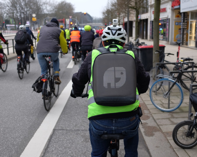 Ride of Silence mit mehreren Radfahrern; Rucksack zeigt Natenoms Elefanten-Logo